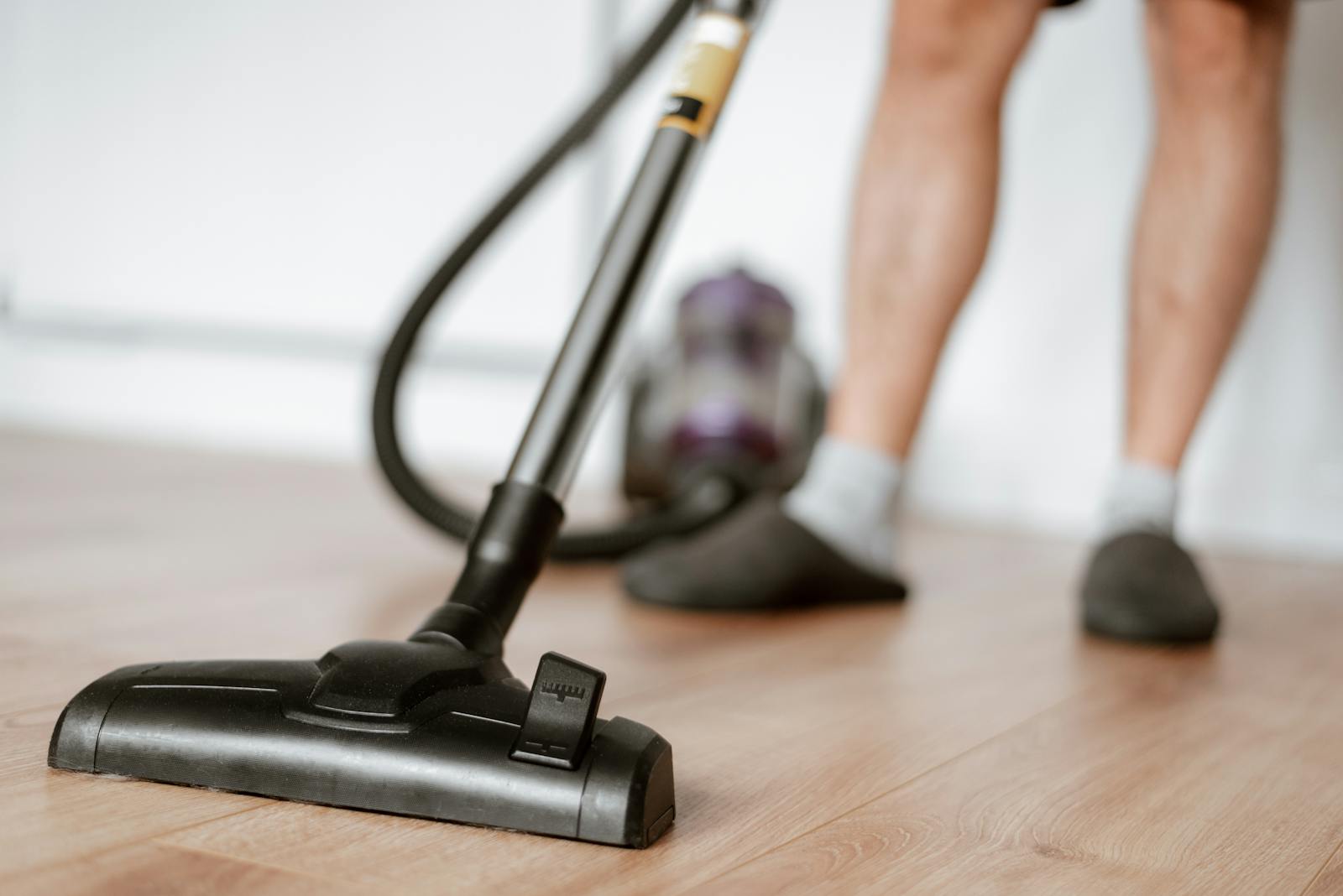 Man cleaning floor with vacuum cleaner
